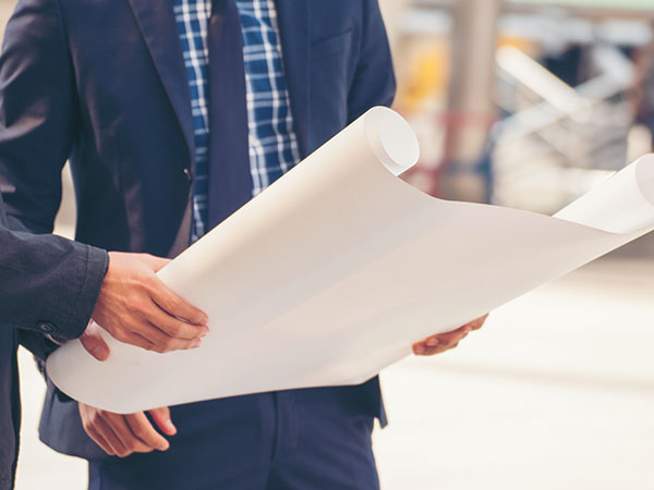 Suited man reviewing blueprints